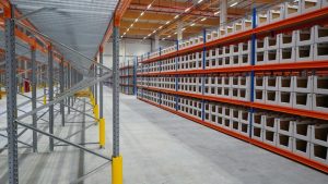 Warehouse interior featuring industrial pallet racking systems with multiple shelves, designed for efficient storage and organization of goods in a large space.
