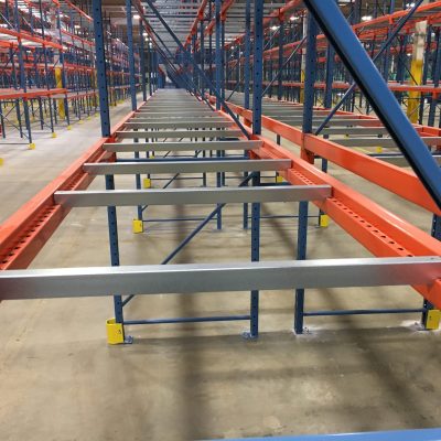 Pallet racking system featuring orange and blue beams in a spacious warehouse, showcasing used pallet rack beams ready for installation in Arlington, TX.